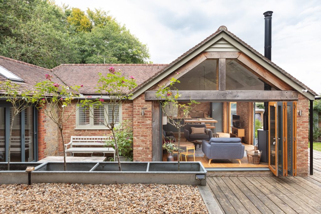 The garden, decking and open-plan dining area of Badgers Cottage, a dog friendly cottage in Sussex