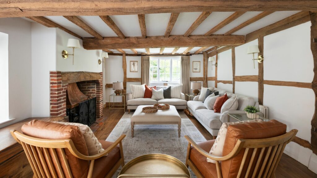 The stunning living room complete with exposed beams and fireplace of Marble Bridge Farm, a luxury holiday home and dog-friendly cottage in Sussex. 