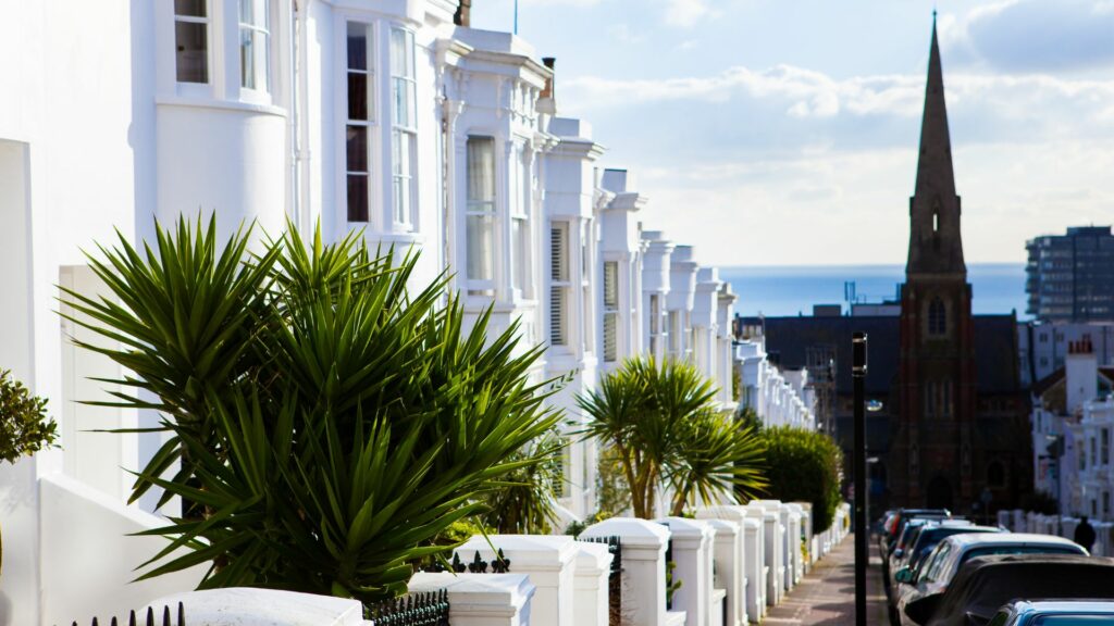 White-washed homes of Brighton with the sea in the distance.